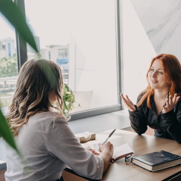Empathy, friendly support, each other's support and sisterhood. Young woman comforting her friend sitting in cafe. Female Psychotherapist supporting her depressed patient